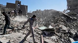 A group of men inspects the ruins of a police station struck Monday amid the strikes on Tehran, 3 March 2026