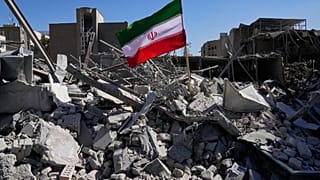 تم وضع علم إيراني بين أنقاض مركز شرطة استُهدف يوم الإثنين خلال الحملة العسكرية الأمريكية-الإسرائيلية في طهران، إيران