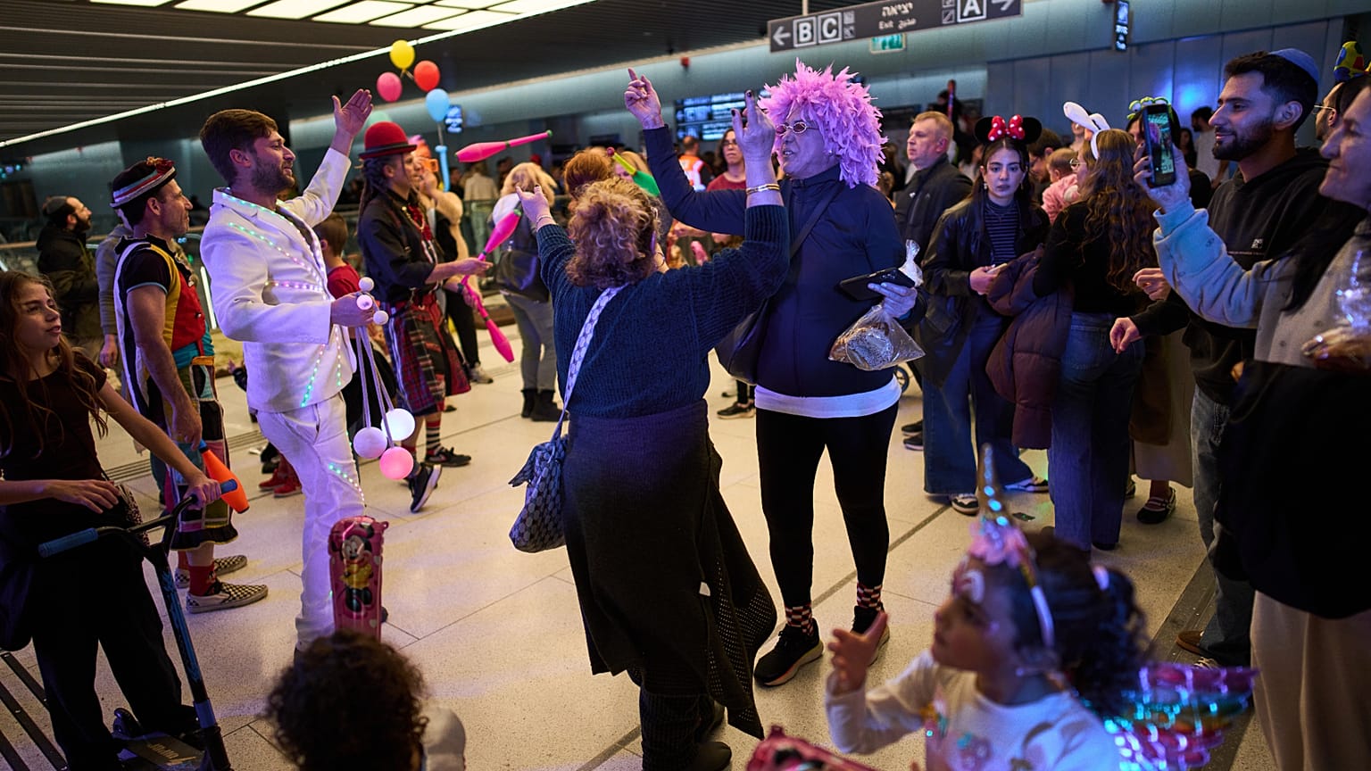 People, some wearing costumes, celebrate the Jewish holiday of Purim in an underground metro station used as a shelter against possible Iranian missile attacks, in Ramat Gan