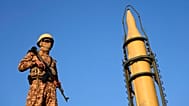 FILE: An Iranian armed forces member stands guard in front of a domestically-built missile displayed during the Basij paramilitary force parade in Tehran, 10 January 2025