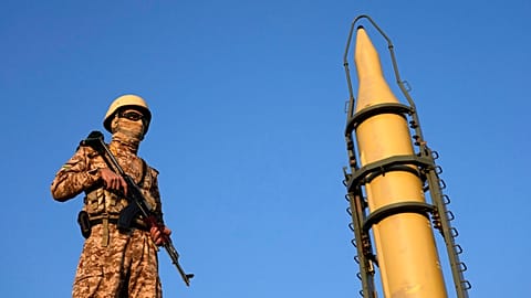 FILE: An Iranian armed forces member stands guard in front of a domestically-built missile displayed during the Basij paramilitary force parade in Tehran, 10 January 2025