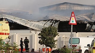 يعمل رجال الإطفاء بينما يتصاعد الدخان خارج مستودع متضرر في منطقة صناعية بمدينة الريان في قطر، عقب غارة إيرانية، الأحد 1 مارس 2026. (صورة من وكالة أسوشيتد برس)