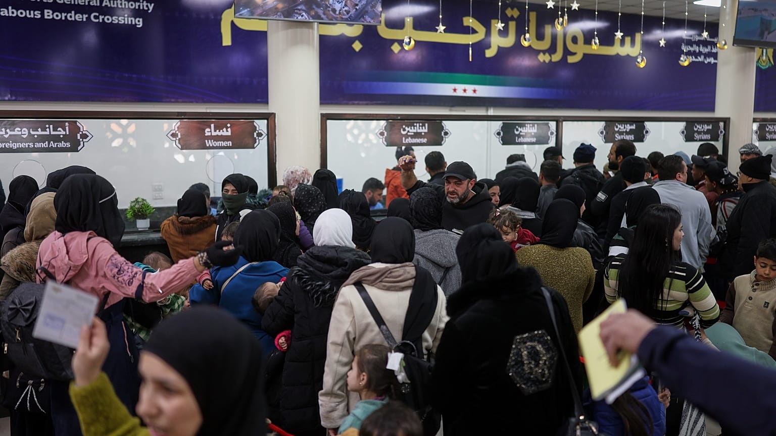 يصطف السوريون واللبنانيون عند مراقبة الجوازات أثناء عبورهم الحدود السورية اللبنانية إلى سوريا، هربًا من لبنان بسبب الغارات الجوية الإسرائيلية، في جديدة يابوس، سوريا 