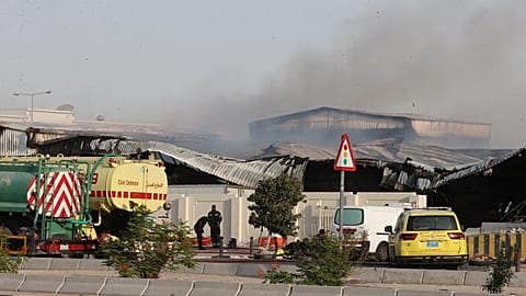 Os bombeiros trabalham enquanto o fumo se eleva no exterior de um armazém danificado numa zona industrial em Al Rayyan, no Qatar, na sequência de uma greve iraniana, a 1 de março de 2026. 