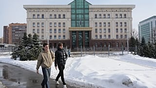 St. Petersburg Şehir Mahkemesi'nin önündeki yolda yürüyen insanlar.