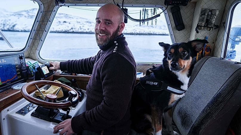 Helgi Aargil, fisherman, with his dog Molly, sails on his boat near Nuuk, Greenland, on Wednesday, Jan. 21, 2026. 