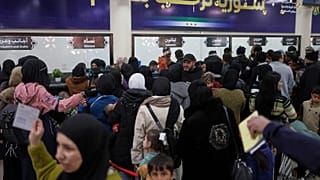 Syrians and Lebanese queue up at passport control as they cross the Syrian-Lebanese border into Syria, fleeing Lebanon due to Israeli airstrikes, in Jdeidet Yabous, Syria 