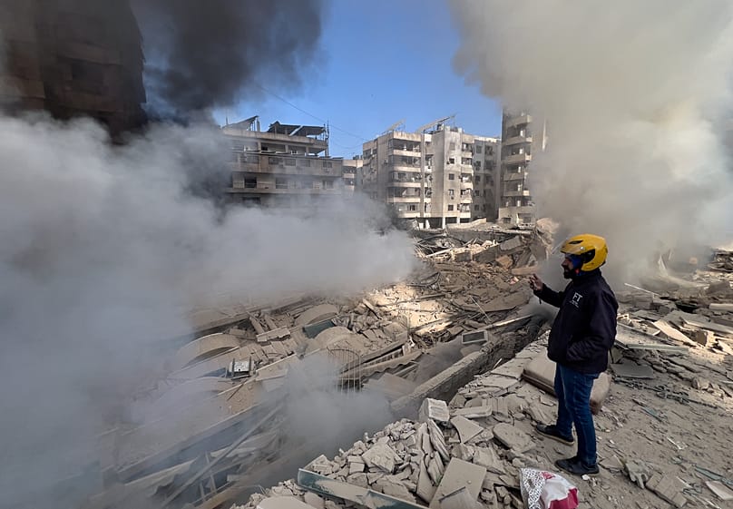 رجل يلتقط صورًا بهاتفه لمبانٍ استهدفتها غارات إسرائيلية في الضاحية الجنوبية لبيروت في لبنان، 3 مارس 2026.