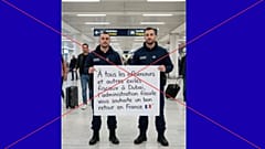 Bild von französischen Grenzbeamten, die ein Schild für Personen halten, die aus Dubai kommen