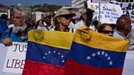 Unos manifestantes en Caracas portando banderas venezolanas.