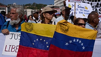Unos manifestantes en Caracas portando banderas venezolanas.