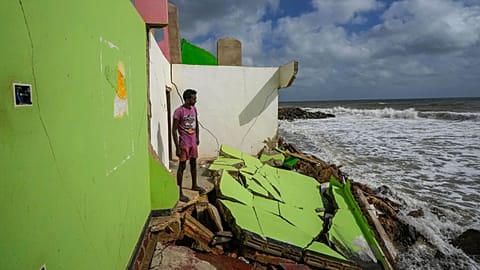 FILE - Dilrukshan Kumara looks at the ocean as he stands by the remains of his family's home in Iranawila, Sri Lanka, June 15, 2023. 