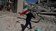 Ein Mann trägt eine iranische Flagge auf die Trümmer einer Polizeieinrichtung, die während der amerikanisch-israelischen Militäraktion in Teheran, Iran, getroffen wurde, Mittwoch, 4. März 2026.