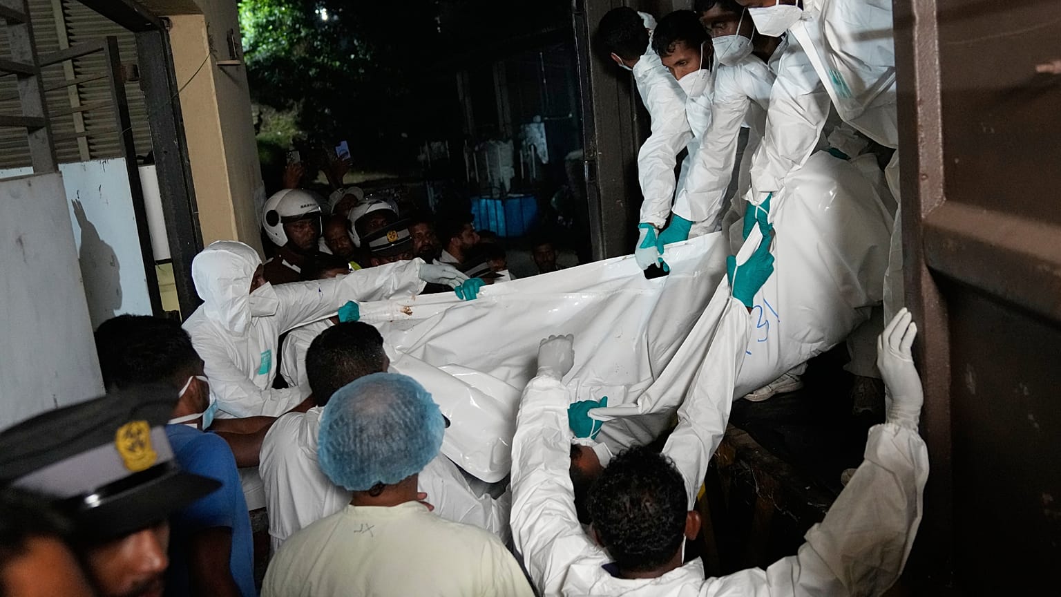 عمال الرعاية الصحية ينزلون من سيارة جثث البحارة الإيرانيين الذين لقوا حتفهم عندما غرقت سفينتهم الحربية "آيريس دينا" خارج المياه الإقليمية لسريلانكا، في جالي، سريلانكا، الأربعا