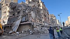 Arbeiter versammeln sich vor einem zerstörten Gebäude in Dahiyeh, einem Vorort Beiruts, nach israelischem Luftangriff am fünften März zweitausendsechsundzwanzig.