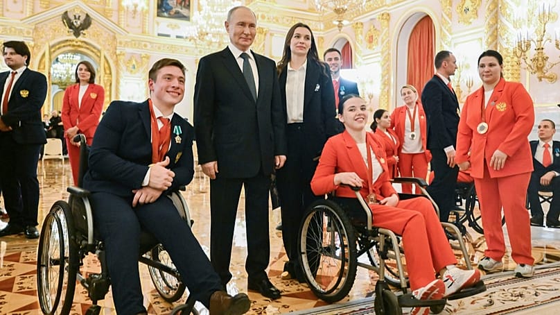 ARCHIV – Putin posiert am 16.12.2024 in Moskau mit den Paralympics-Athleten Alexei Churkin (Silber, Kugelstoßen) und Evgeniia Galaktionova (Bronze, Speerwurf)