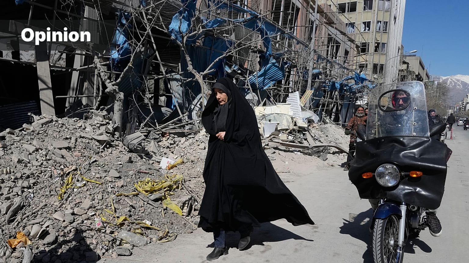 A woman walks past a building which was damaged after a strike on a police station amid the U.S.–Israeli military campaign in Tehran, Iran, Tuesday, March 3, 2026.