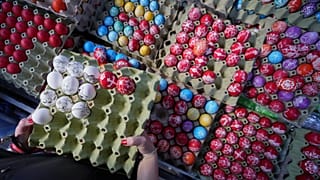 Eine Käuferin wählt am orthodoxen Karfreitag, dem 18. April 2025, auf einem Grünmarkt in Belgrad, Serbien, handverzierte Ostereier aus.