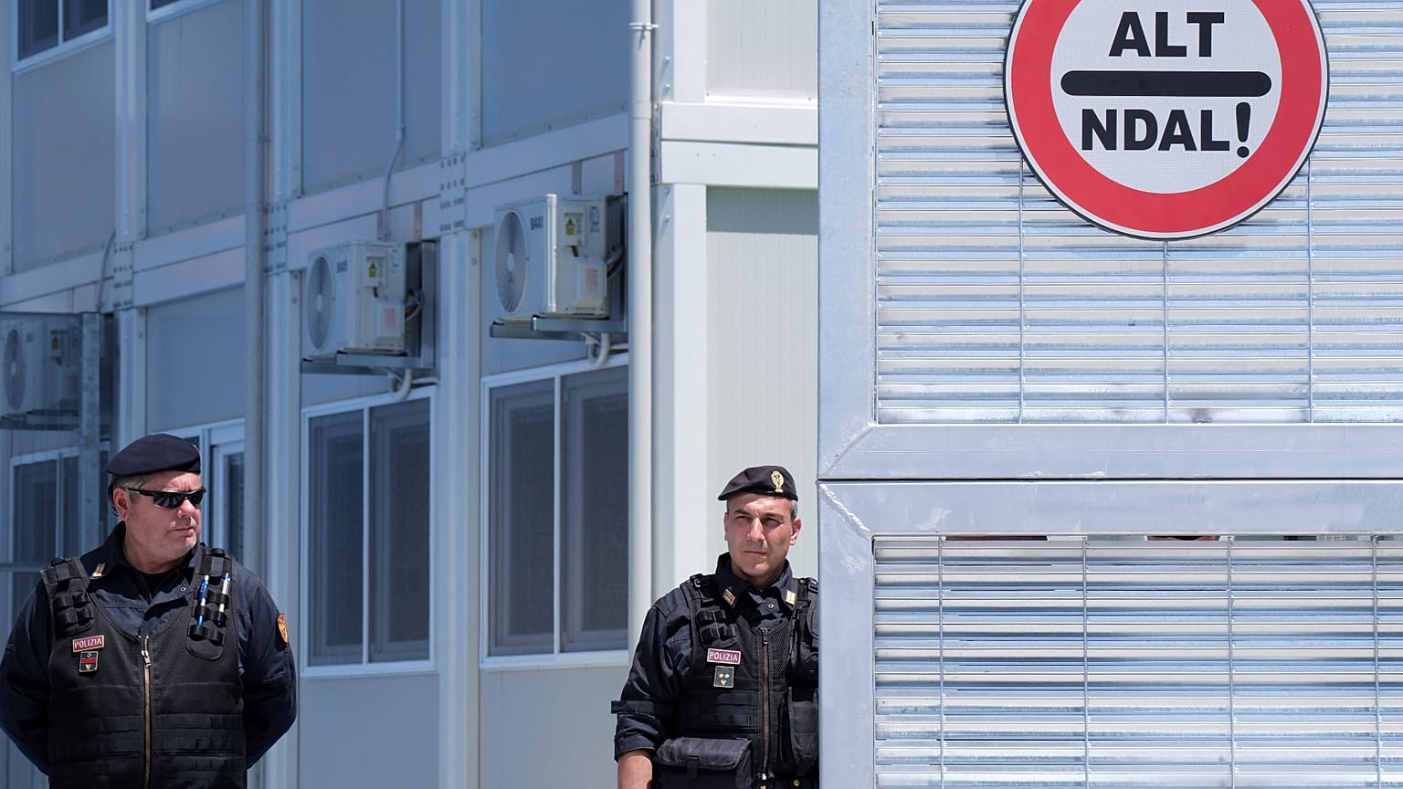 Police guard a reception center for migrants, at the port of Shenjin, northwestern Albania. These centres are considered as a model for return hubs