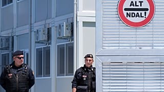 Police guard a reception center for migrants, at the port of Shenjin, northwestern Albania. These centres are considered as a model for return hubs