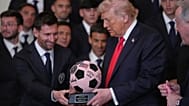 Donald Trump elnök egy futball-labdát ábrázoló trófeát vesz át Lionel Messitől egy rendezvényen, amelyen a 2025-ös MLS-bajnok Inter Miamit ünneplik.