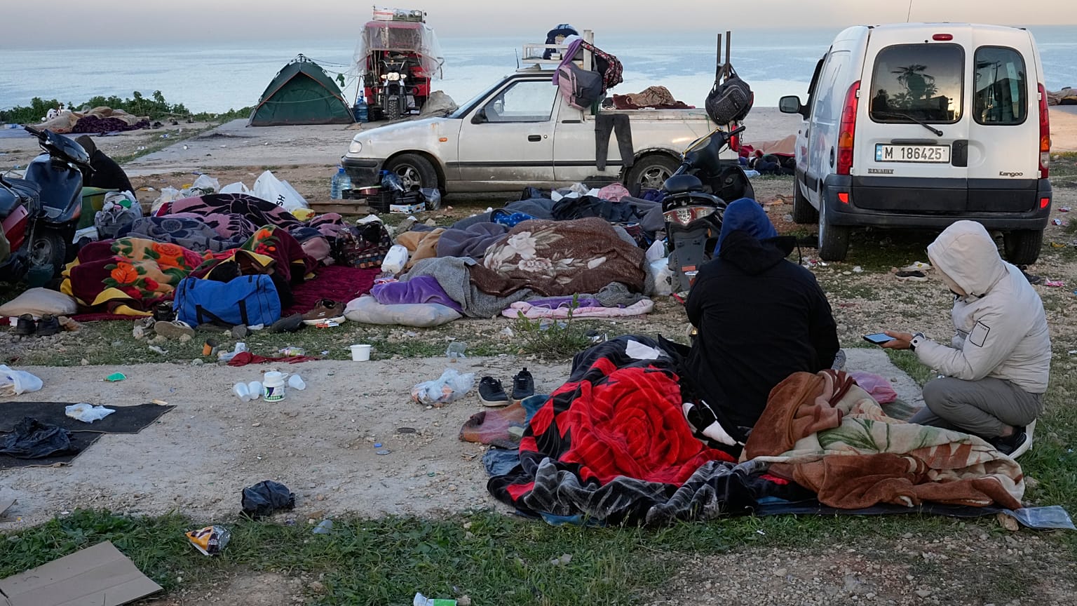 Displaced people fleeing Israeli airstrikes in Beirut's southern suburb of Dahiyeh rest on the Beirut corniche