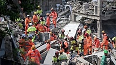 Feuerwehrleute durchsuchen die Trümmer eines eingestürzten Pflegeheims, in dem mindestens sechs Menschen ums Leben kamen.
