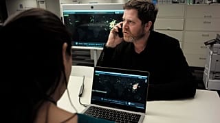 John Brownstein, right, co-founder of HealthMap, a system using artificial intelligence to monitor global disease outbreaks, speaks on a phone in a HealthMap work area at Bost