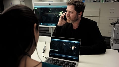 John Brownstein, right, co-founder of HealthMap, a system using artificial intelligence to monitor global disease outbreaks, speaks on a phone in a HealthMap work area at Bost
