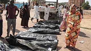 يتفقد أقارب الضحايا أكياس جثث ضحايا النزاع المستمر منذ عامين في السودان، بعد أن نقلت هيئة الهلال الأحمر السوداني الرفات من قبور مؤقتة إلى مقبرة محلية في الخرطوم