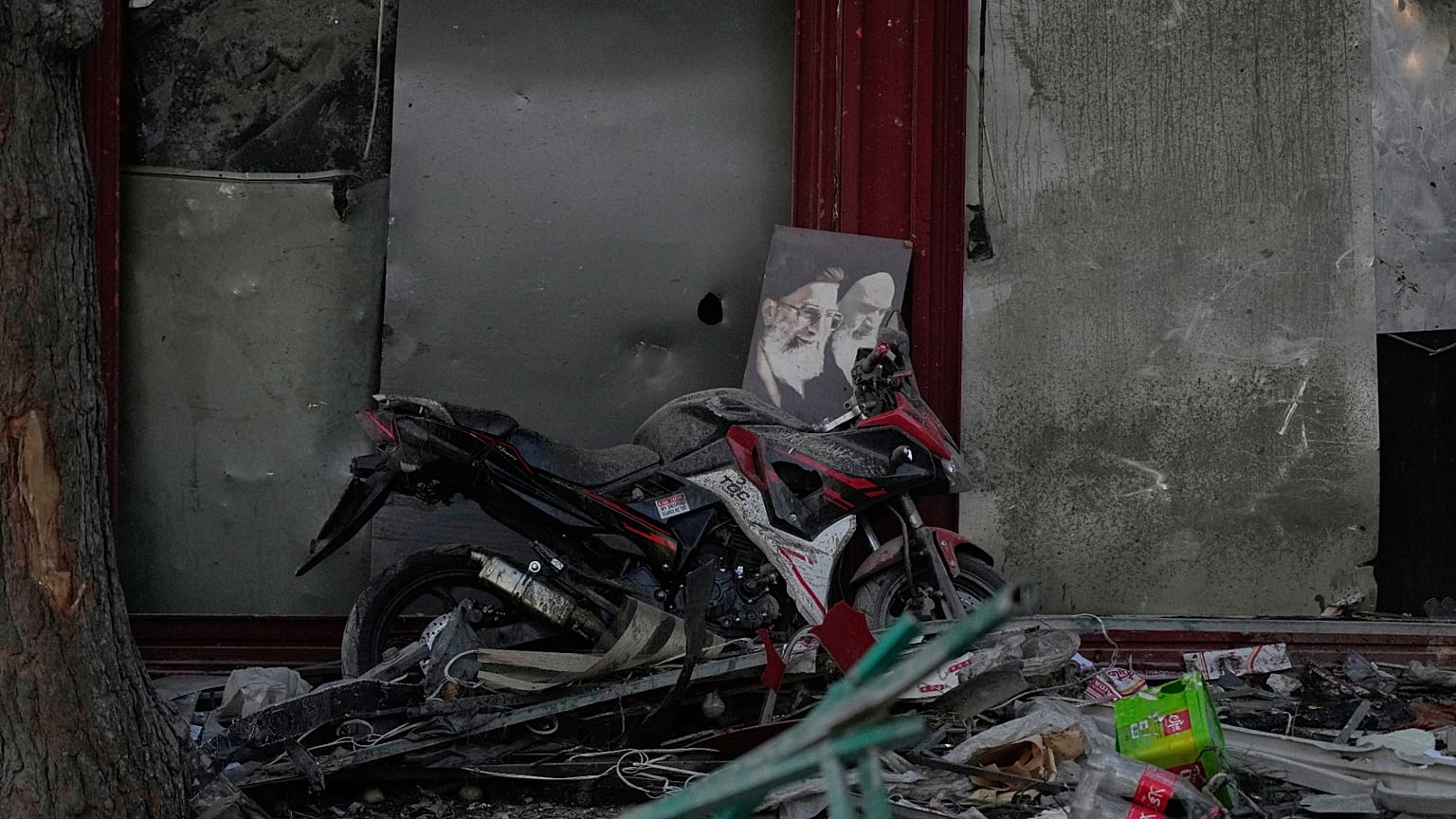 ملصق للمرشد الإيراني علي خامنئي ومؤسس الثورة الإيرانية آية الله روح الله الخميني ملقى على دراجة نارية وسط الأنقاض في طهران، الاثنين 2 مارس 2026.