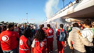 أشخاص يستقبلون عدداً من الناشطين المشاركين في "أسطول الصمود العالمي" بعد الإفراج عنهم من سجون إسرائيل، لدى وصولهم إلى تونس، في 5 أكتوبر 2025.