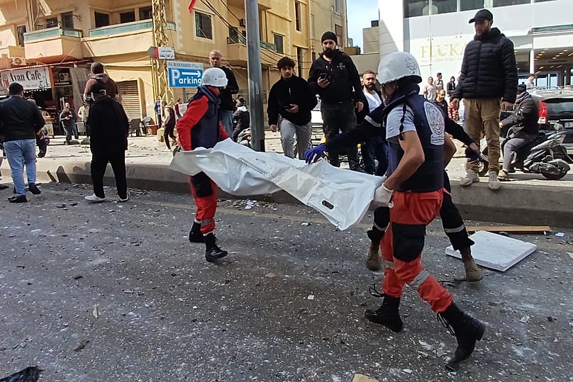 Des secouristes transportent le corps d'une personne tuée par une frappe aérienne israélienne dans la ville portuaire de Sidon, dans le sud du Liban, le vendredi 6 mars 2026.