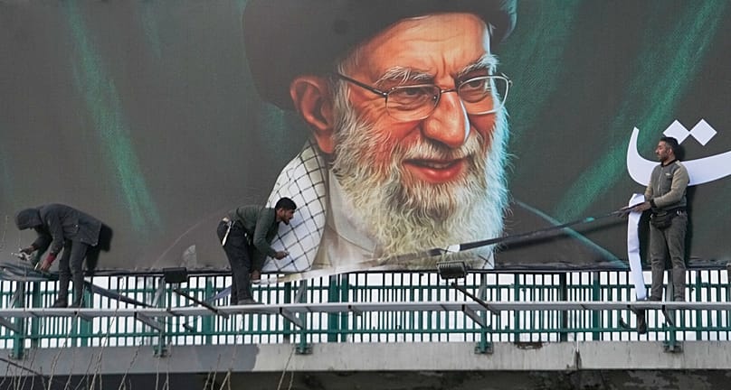 Workers install a billboard of late Iranian Supreme Leader Ayatollah Ali Khamenei in Tehran, 2 March, 2026