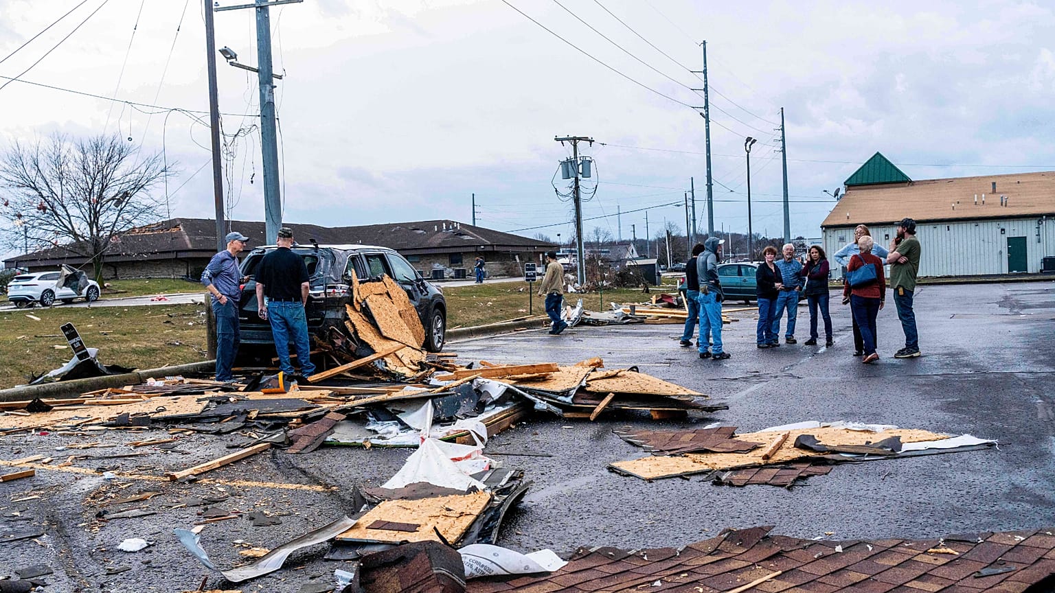Patrons stand outside and view damage to a Holiday Inn after a reported tornado in Three Rivers, Mich., on Friday, March 6, 2026.