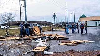 Patrons stand outside and view damage to a Holiday Inn after a reported tornado in Three Rivers, Mich., on Friday, March 6, 2026.