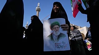 امرأة تحمل صورة المرشد الأعلى الإيراني الراحل علي خامنئي، بينما يسير أنصار الحكومة في مسيرة احتجاجًا على الحملة العسكرية الأمريكية-الإسرائيلية الجارية،