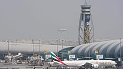 FILE - Ένα Boeing 777 της Emirates στέκεται στην πύλη του Διεθνούς Αεροδρομίου του Ντουμπάι, ενώ ένα άλλο ετοιμάζεται να προσγειωθεί στον διάδρομο προσγείωσης στο Ντουμπάι, Ηνωμένα Αραβικά Εμιράτα, 17 Αυγούστου 2022.