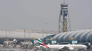 FILE - An Emirates Boeing 777 stands at the gate at Dubai International Airport as another prepares to land on the runway in Dubai, United Arab Emirates, Aug. 17, 2022.