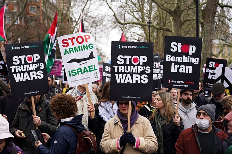 Demonstrators hold flags and placards as they attend a Stop the War Coalition march in London, Saturday, March 7, 2026.