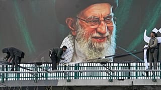 Workers install a billboard of the late Iranian Supreme Leader Ayatollah Ali Khamenei in Tehran, 2 March, 2026