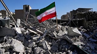 رچم ایران در میان ویرانه‌های یک ایستگاه پلیس که روز دوشنبه در جریان کارزار نظامی آمریکا و اسرائیل در تهران هدف حمله قرار گرفت