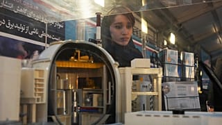 طالبة تنظر إلى نموذج لمحطة بوشهر للطاقة النووية في معرض للإنجازات النووية للبلاد، في طهران، إيران، الأربعاء 8 فبراير 2023.