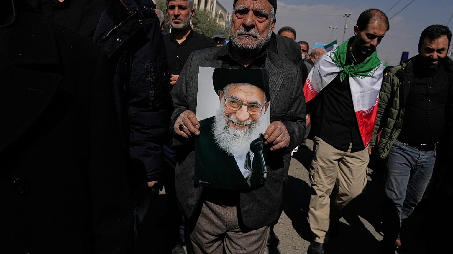 رجل يحمل صورة المرشد الأعلى الإيراني الراحل آية الله علي خامنئي