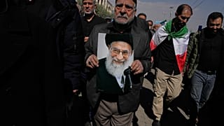 رجل يحمل صورة المرشد الأعلى الإيراني الراحل آية الله علي خامنئي