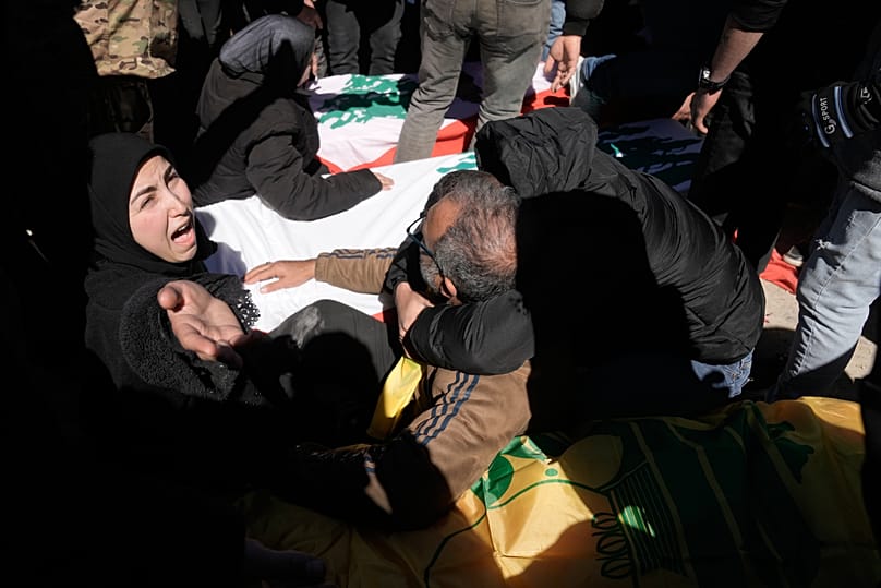 Une femme pleure à côté des corps de combattants du Hezbollah et de soldats libanais tués par des frappes aériennes israéliennes  le dimanche 8 mars 2026. 