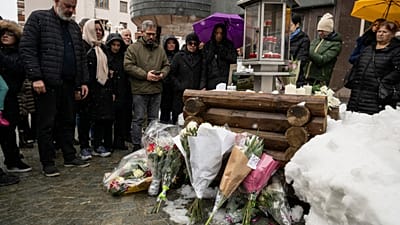 Familiares das vítimas guardam um minuto de silêncio à porta do bar Constellation em Crans-Montana, na Suíça, no sábado, 14 de fevereiro de 2026.