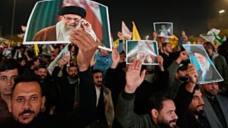 Iraqi Shiites hold pictures of Iranian supreme Leader Ayatollah Ali Khamenei, who was killed by a U.S. airstrike in Tehran