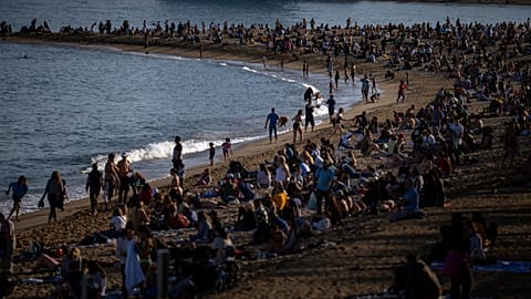 FILE - People sunbathe on a beach in Barcelona, Spain, Sunday, March 12, 2023.