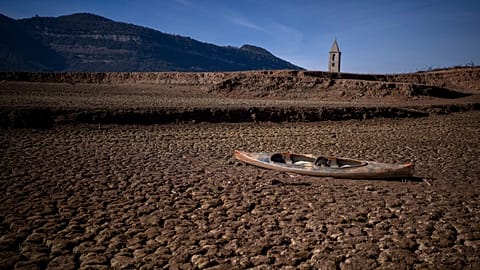 FILE - An abandoned canoe sits on the cracked ground amid a drought at the Sau reservoir, north of Barcelona, Spain, Monday, Jan. 22, 2024. 